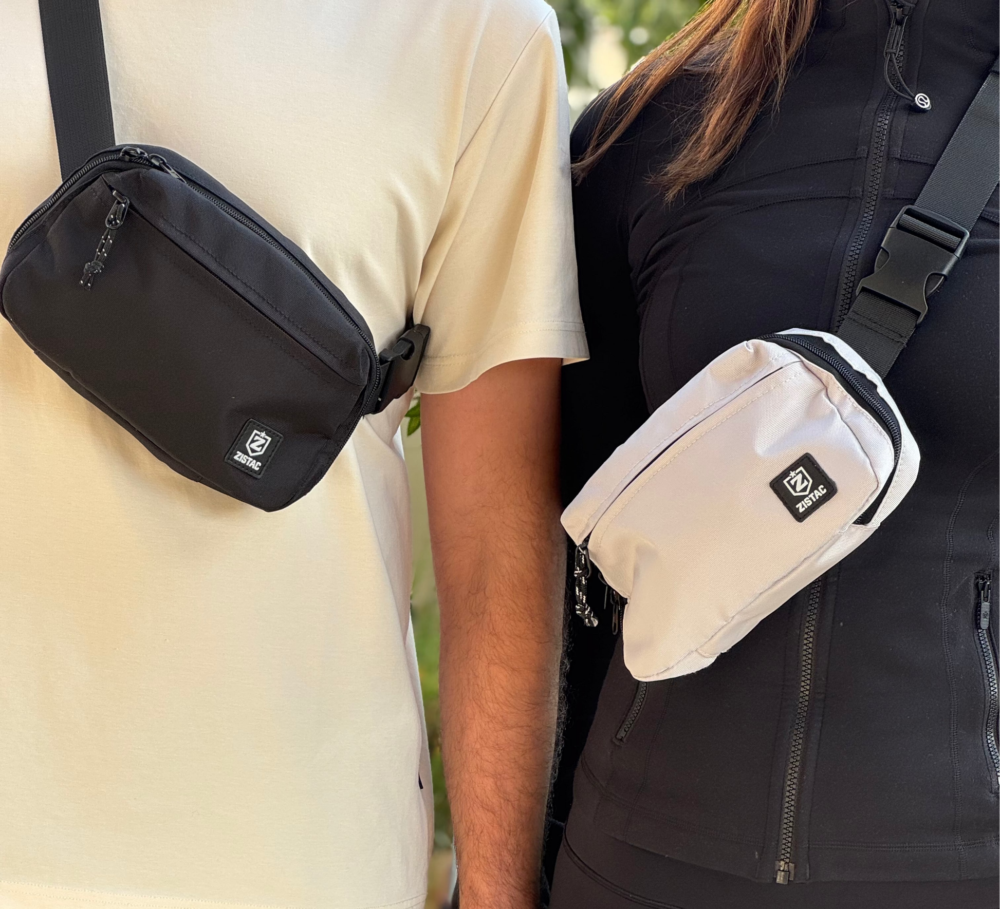 Two people holding hands, each wearing a crossbody bag.